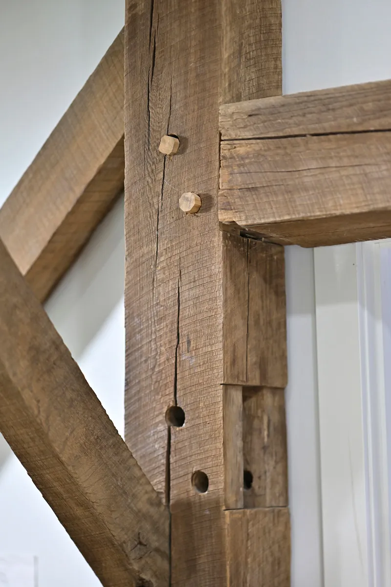 Pegged mortise and tenon joinery detail in a reclaimed oak timber frame