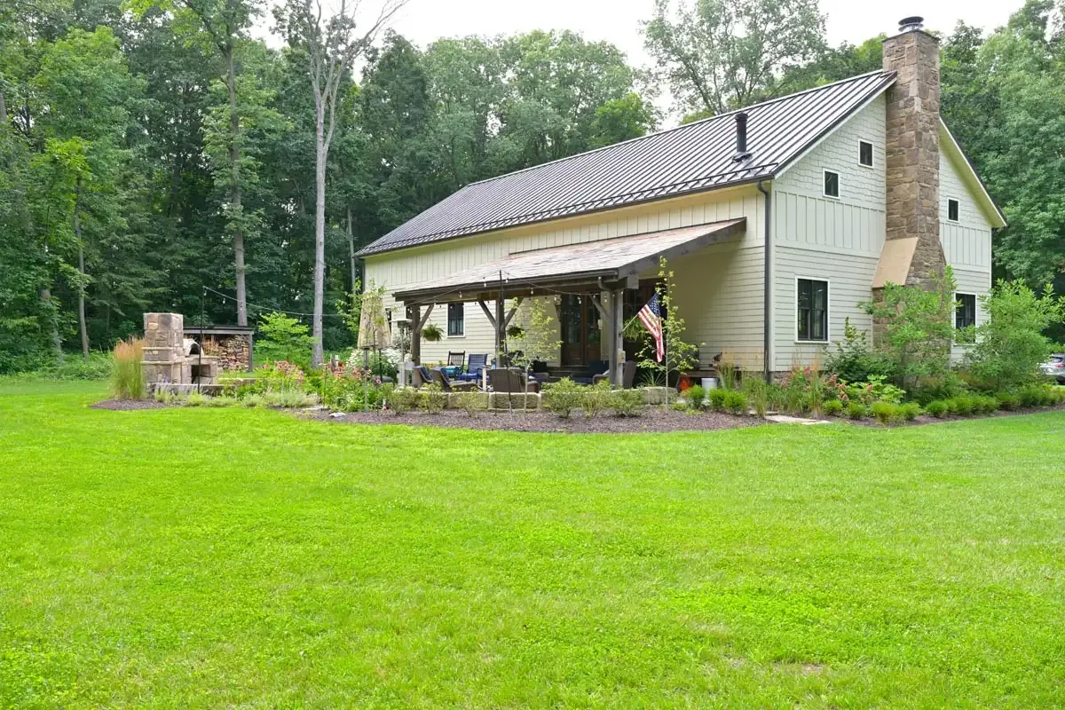 Completed Delaware, Ohio timber frame barn home with board siding, metal roof and stone chimney