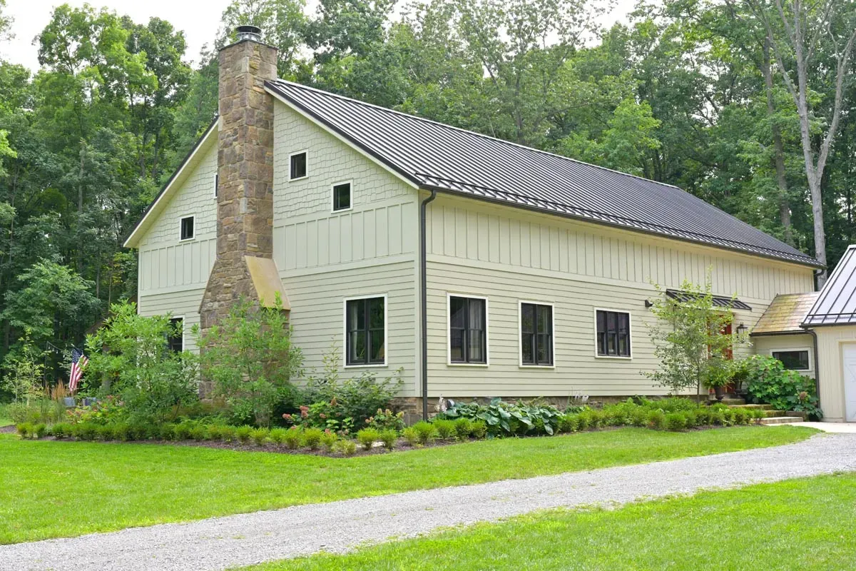 Barndominium-style bedroom under exposed historic timbers in Delaware, Ohio