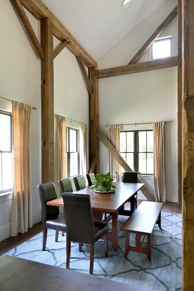 Formal dining space beneath restored German bank barn timbers in Delaware, Ohio
