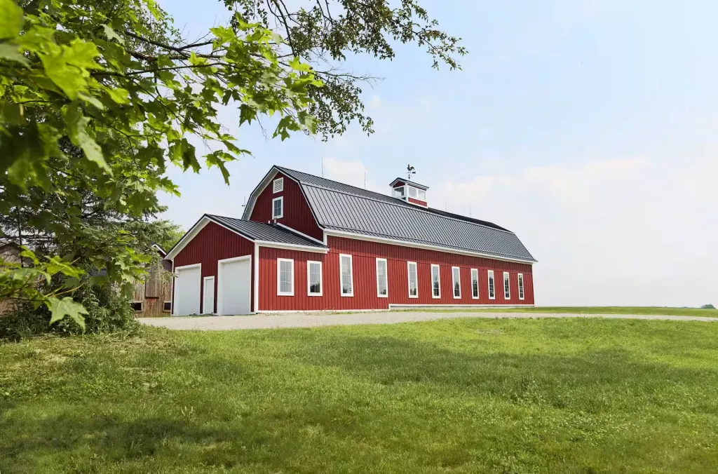 Restored red gambrel Gervy Barn near Oberlin, Ohio with white trim and standing seam metal roof