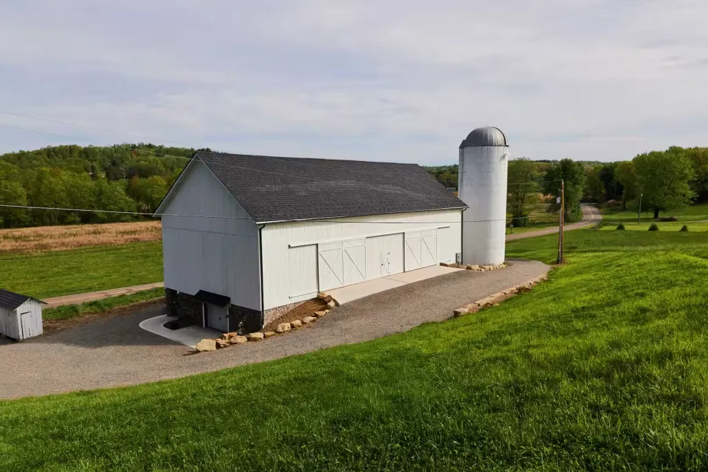 Restored Mason Farms bank barn in Dover, Ohio with white siding and stone foundation