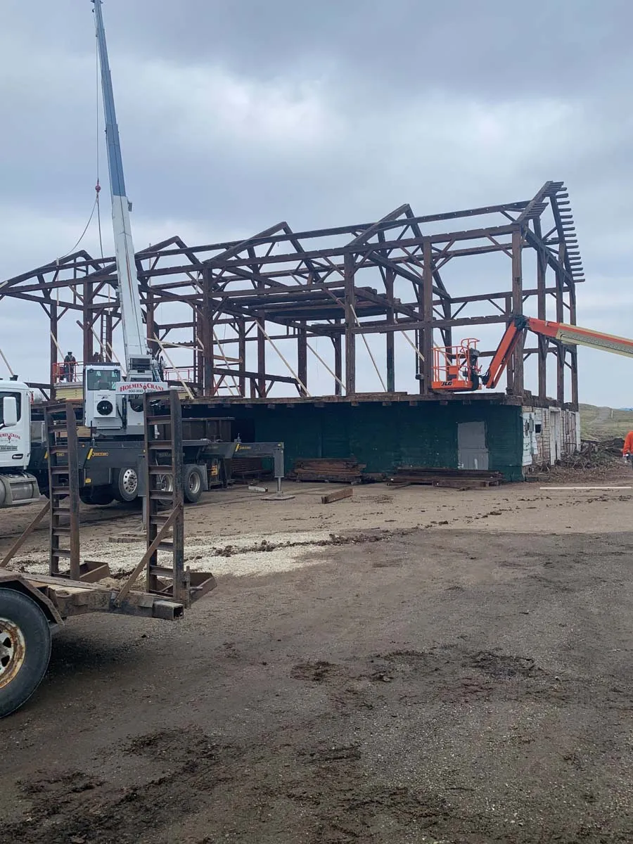 Reclaimed timber frame skeleton raised by crane during an Ohio barn relocation