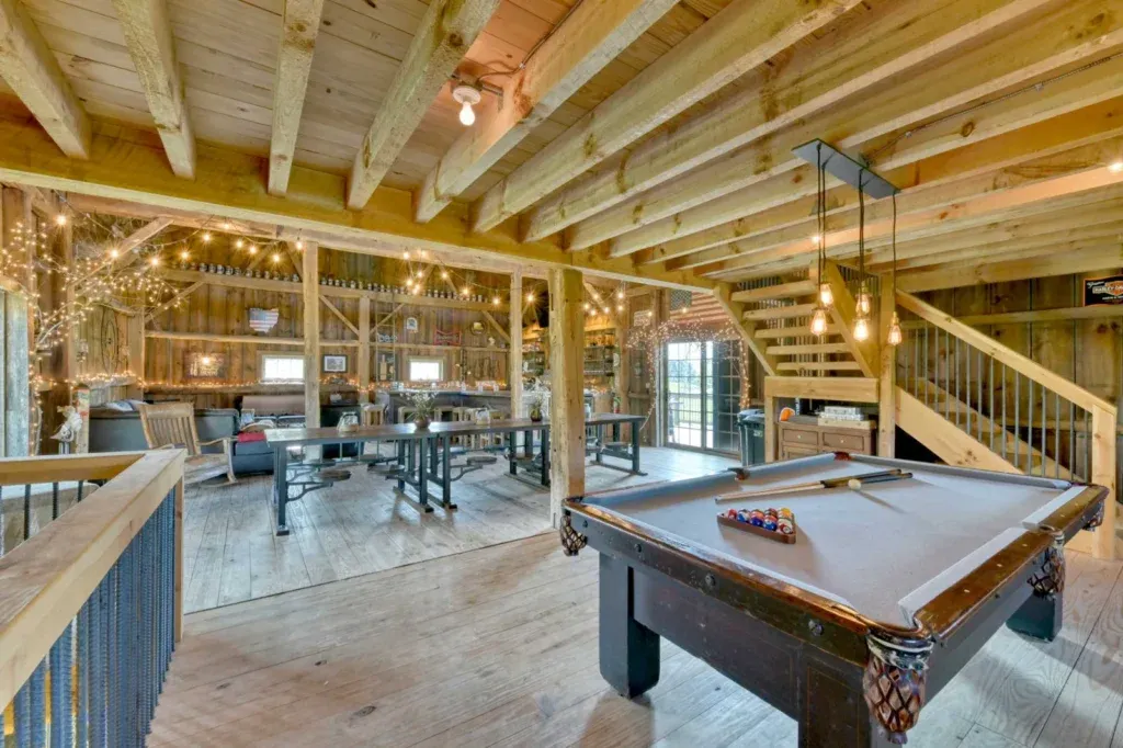 Preserved hand-hewn timber frame interior with entertainment area inside the Richardson Party Barn in Stow, Ohio
