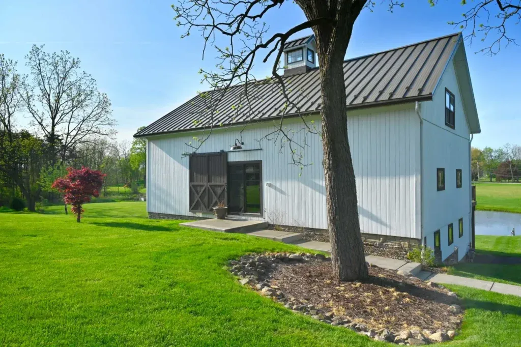 Richardson Party Barn in Stow, Ohio — converted white timber frame barn with black metal roof and stone wainscoting