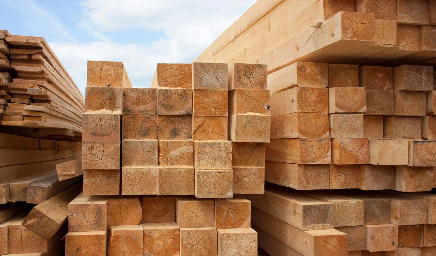 Stacked reclaimed timber beams awaiting restoration at Sugarcreek Builders in Sugarcreek, Ohio
