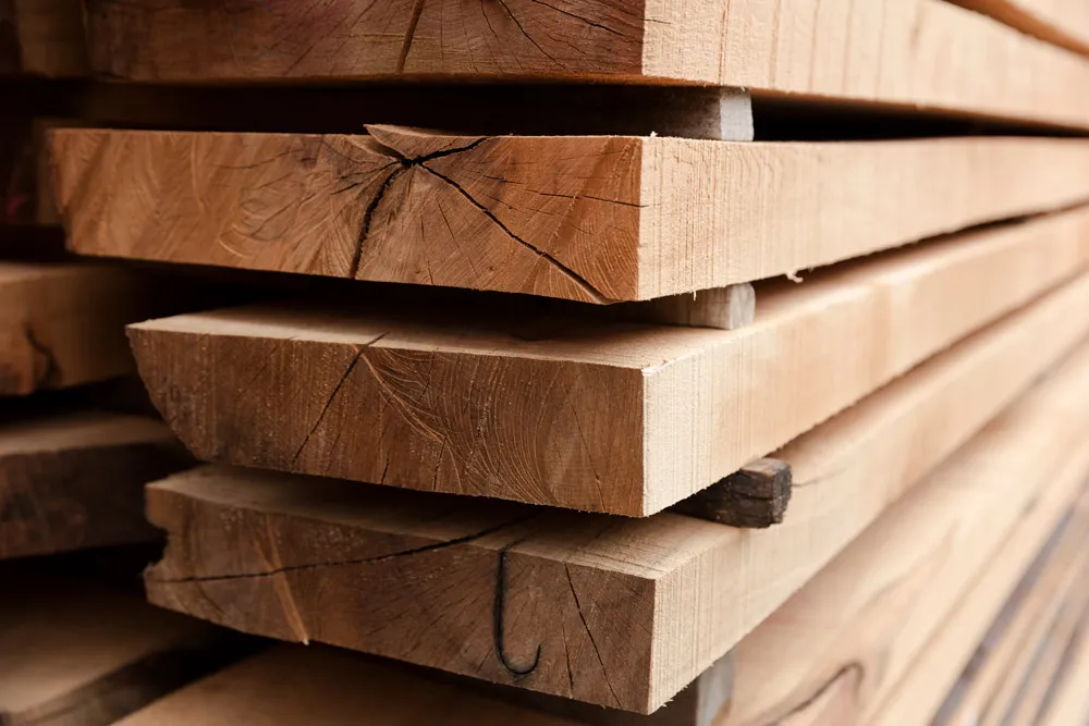 Close-up of stacked rough-sawn reclaimed timber beams used in post-and-beam construction